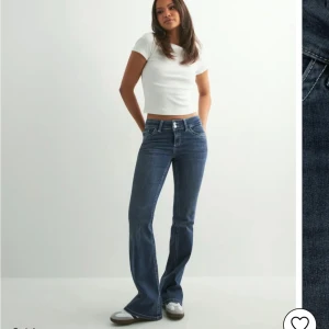 Blå bootcut jeans med kontrastsömmar - Snygga blå jeans med bootcut-modell och markerade kontrastsömmar. Klassisk femficksdesign och coola broderade bakfickor. Jeansen har låg midja och är tillverkade i stretchigt denim för en bekväm passform.