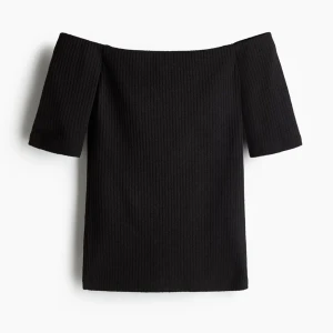 Svart ribbad offshoulder topp - Snygg svart ribbad topp med offshoulder-design och korta ärmar. Perfekt för dig som vill ha en stilren och trendig look. Toppens ribbade material ger en cool struktur och sitter skönt på kroppen.