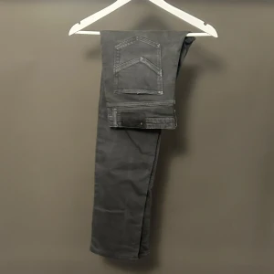 Svarta Slim jeans från Zadig & Voltaire - Snygga svarta Slim jeans från Zadig & Voltaire med coola bakfickor och en liten dödskalle-detalj på läderpatchen. Jeansen har klassisk femficksdesign och är tillverkade i stretchig bomullsmix för en tight passform.