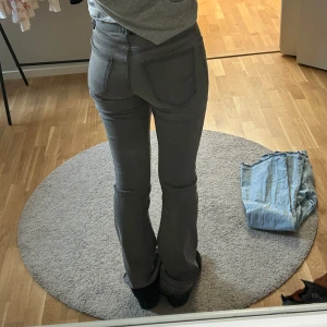 Grå bootcut jeans - De är i storlek 170 i barn men passar mig som 173cm lång och som vanligvis har s/m i jeans. Stretchiga i materialet. Har såret upp de nertill som syns på bilden.