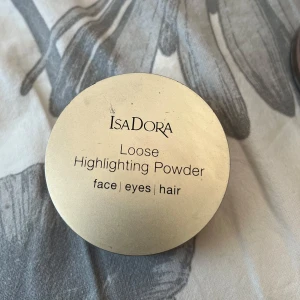 Isadora Loose Highlighting Powder Golden Glow - Lös highlighter från Isadora i nyansen 50 Golden Glow. Ger en skimrande, guldig lyster till ansikte, ögon och hår. Kommer i en rund burk med silkeslen, lätt formula som är enkel att applicera för en glowig finish, använd ksk 3-5 ggr, tips : blanda ner lite i kroppsolja så får du glow! 