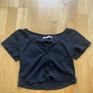 Svart croppad topp från Lager 157 - Svart croppad topp från 157 med korta ärmar och knappar framtill. Gullig och skön nu till sommaren.