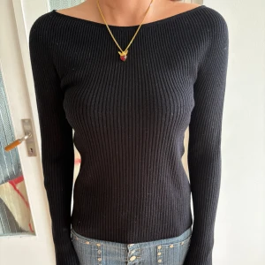 Svart ribbad tröja från Uniqlo - Säljer en svart, ribbad långärmad tröja från Uniqlo i storlek S. Tröjan har en tight passform och är tillverkad i ett mjukt stickat material. Perfekt för dig som gillar en enkel men stilren look med smickrande siluett och bredare halsringning.