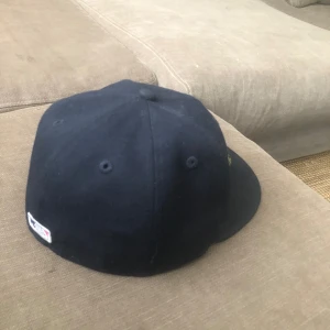 Boston Red Sox keps New Era 59FIFTY - Snygg mörkblå Boston Red Sox keps från New Era, modell 59FIFTY. Klassisk basebollkeps med röd och vit broderad B-logga framtill och New Era-logga på sidan. Rak skärm och broderade ventilations