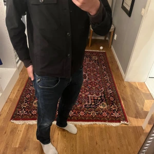Mörkblå Replay jeans slim fit - Snygga mörkblå jeans från Replay med klassisk  och diskreta slitningar. Jeansen har slim passform och sitter väldigt snyggt på. Storlek 34/34. Skriv vid fundering eller frågor!