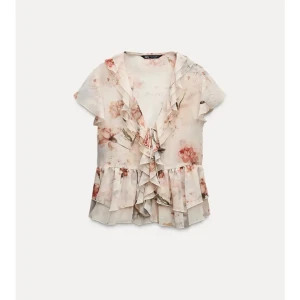 Blommig volangblus från Zara - Supersöt blommig blus från Zara i ljusa toner med volanger längs v-ringningen och nertill. Korta ärmar och knyt framtill ger en romantisk vibe. Perfekt för vår och sommar när du vill känna dig extra fin. Aldrig använd med lappen kvar⭐️