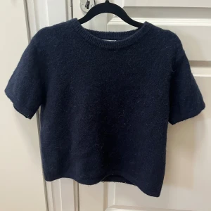 Mörkblå stickad tröja Gina Tricot - Mysig mörkblå stickad tröja från Gina Tricot i storlek 158/164. Tröjan har korta ärmar, rund halsringning med ribbad kant och en enkel, rak passform. Perfekt för lager-på-lager och chill dagar. Jätte snygg tröja men kommer inte till användning och inte alls använd många gånger 🥰