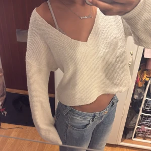 Vit croppad stickad tröja - Supermysig vit stickad tröja med v-ringning och croppad passform. Tröjan har långa ärmar och en lite loose fit, perfekt att styla med jeans eller kjol. Storlek M , men ska sitta lite loose💞💞