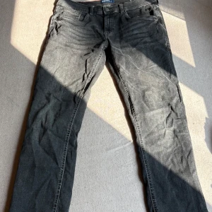 Svarta slim jeans från Blend - Säljer ett par svarta jeans från Blend, modell Twister Slim. Jeansen har fem fickor, klassisk knappgylf och en snygg tvättad look. Passformen är slim och materialet är mjukt denim som sitter skönt hela dagen.