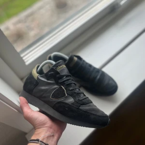 Philippe Model trpx  - Säljer ett par svarta sneakers från Philippe Model med detaljer i mocka och skinn. Det är en unik kombo av färger som gör det unikt och snyggt. Strl 40! Använda vid få tillfällen!