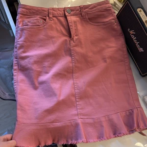 Rosa jeanskjol med volangkant - Supersöt rosa jeanskjol med volang och rå kant längst ner. Kjolen har klassiska fickor fram och bak samt hällor för bälte. Knappt använd💖💖