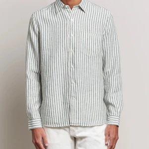 Randig linneskjorta från A Day's March - Snygg randig skjorta från A Day's March i 100% linne. Skjortan är vit med smala gröna ränder, använder inte då den är för liten för mig. Orginalpris: 1199kr