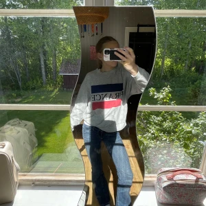 Grå sweatshirt FRANCE Gina Tricot - Grå sweatshirt från Gina Tricot med tryck FRANCE och blockfärger i blått och rött framtill. Tröjan har rund hals, långa ärmar och en relaxed passform. Perfekt för dig som gillar en chill och sportig vibe.