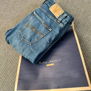 Blå Nudie Jeans - Säljer ett par nudie jeans, de är i riktigt bra skick och har börjat få en riktigt snygg fade.  Storlek: W28 L32. Modell: Gritty Jackson. De har straight passform. Priset är kan prutas ner vid en snabb affär. SKRIV VID FUNDERINGAR🙃!