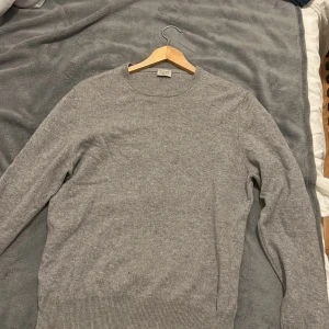 Grå kashmirtröja från Rose & Born - 100% Kashmir. 6500kr nypris. 1 pyttelitet hål därför säljs den för att jag kan inte jobba i den längre pågrund av klädpolicy. Men säljer gärna vidare den då den är i gott skick.