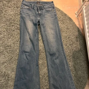 Blå jeans från Levi's - Snygga blå jeans från Levi's med bootcut-stil. De har en klassisk femficksdesign och en dragkedja med knappstängning. Perfekta för en avslappnad look. Midjemåttet är 68💕