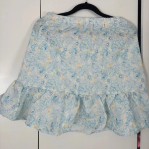 Blommig kjol med volang - Fin sommarkjol med volanger i pastellfärger