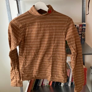 Brun randig polotröja från Miss Sumey - Säljer en brun polotröja från Miss Sumey med vita ränder och ett broderat rött hjärta på kragen. ❤️Finns ingen storlek på men skulle uppskatta är den är en small eller medium.