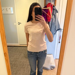 Ljusrosa t-shirt från Bondelid - Säljer en stilren ljusrosa t-shirt från Bondelid med ett diskret tryck på framsidan. T-shirten har en klassisk rund hals och korta ärmar. Perfekt för en avslappnad look.