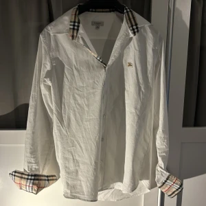 Burberry skjorta - Säljer en stilren vit skjorta från Burberry. Perfekt för en elegant somrig look. 