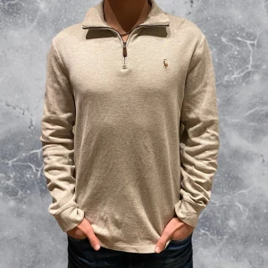 Ralph Lauren Quarter Zip tröja  - •Ralph Lauren Quarter Zip tröja beige. Skick: 8/10, Inga skador! Storlek: S. Modell: 173 cm, 63 kg. Authentic: ✅, qr kod finns i plagget! Nypris drygt 2 200 spänn! Hör av dig vid frågor eller funderingar. Mvh Benjamin;)