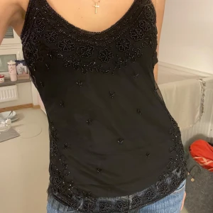 Paljett festtopp - Snyggt svart linne med broderade detaljer och pärlor🌸 OBS!!! Några pärlor har lossnat!!! Därav prissänkningen