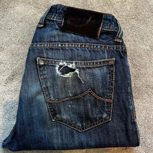 Blå jeans från Jacob Cohën - Skick: 9/10, sköna slitningar - Storlek: 32 - Längd:97cm Midja:40cm ben:18cm - Nypris: 5000 kr+