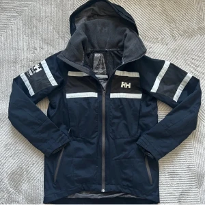 helly hansen - säljer en stilren helly hansen windbreaker i färgen mörk blå inga större defekter varan har små täcken på andvändning om du har övriga frågor är det bara att kontakta oss här på plick👑🫵🤝