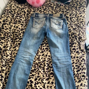 Bootcut low waist miss me jeans  - Snygga blå jeans från Miss Me med coola detaljer på bakfickorna. Midjemått 39cm innebenslängd 85 cm. Såå coola men tyvärr ont emin storlek längre. Är slitna vid hälen 
