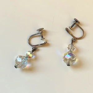 Glittriga örhängen med skruvstängning - Snygga glittriga vintage örhängen med skruvstängning och facetterade kristaller som fångar ljuset. Perfekta för att ge en extra touch av glamour till din outfit. De är ungefär 3 cm långa och har en klassisk design som passar till många tillfällen.