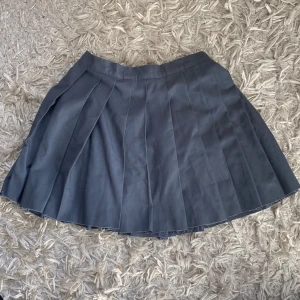 Grå plisserad kjol - Säljer en skolkjolsliknande minikjol med dragkedja i sidan. Bra kvalitet och justerbar. Säljer då den inte är min storlek längre.💕 Passar s-xs men skulle kanske kunna passa medium i och med att den är justerbar.
