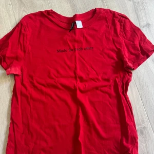 Röd t-shirt med text från H&M - Röd t-shirt från H&M med svart text 'Made for each other' på bröstet. Klassisk rund hals och korta ärmar. Storlek xs. 