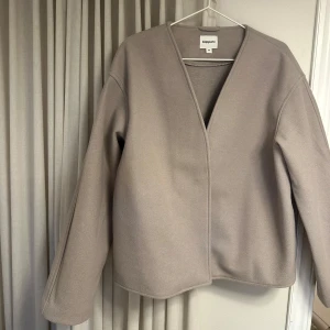 Beige jacka från Kappahl - Säljer en stilren beige jacka från Kappahl. Jackan har en v-ringad design och långa ärmar. Perfekt för en minimalistisk look. Passar bra till både vardag och mer uppklädda tillfällen. Endast provad och aldrig använd.