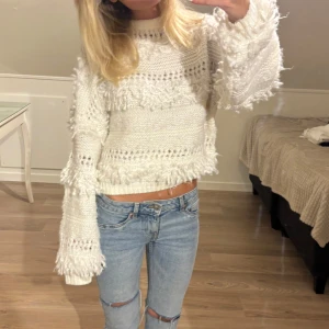 Vit stickad tröja med fransdetaljer - Supermysig vit stickad tröja med fransdetaljer och hålmönster. Storlek M men passar mig som är xs