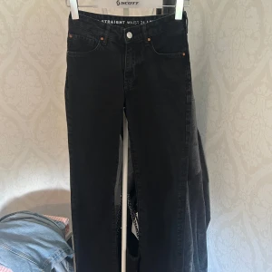 Svarta low waist straight jeans - Snygga svarta jeans med låg midja och raka ben. Klassisk femficksmodell med silverfärgad knapp och. Materialet är jeans och modellen är straight fit.