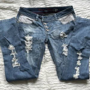 Blå ripped jeans med spetsdetaljer S - Mid-waist jeans. Storleken är S men kommer att passa bäst på någon som ligger mellan M/S, jag skulle tro ungefär w28/9.