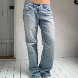 Ljusblå lågmidjad jeans  - Ljusblå lågmidjad jeans med klassisk rak passform och femficksdesign. Jeansen har låg midja och är tillverkade i slitstarkt bomullsjeans. Perfekta för en avslappnad och cool stil.
