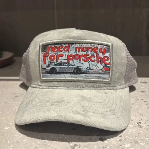 Need Money 4 Porsche – limited edition keps - 🔥 SÄLJER MIN FAVORITKEPS 🔥 Grå trucker-keps från Revenite med fett broderad patch fram: “Need money for Porsche” 🏎️💨 Sitter sjukt skönt, mesh på baksidan så den andas bra – perfekt både till sommaren och till att bara rocka en clean streetlook.  Köpt för 500kr, använd typ inget, ser fresh ut som på bilderna. 👉 One size, justerbar baktill.  Perfekt för dig som gillar bilar, streetwear eller bara vill ha en keps som sticker ut. Pris: 350kr eller bud 💸 