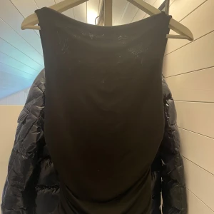 Svart tröja med öppen rygg från Bik Bok - Endast använd 1 gång! Säljer en svart tröja utan rygg från Bik Bok i storlek S. Tröjan är figur sydd i midjan med snygg drapering och en öppen rygg med metall-detalj. Materialet är mjukt och stretchigt, perfekt för dig som gillar stilrena och trendiga plagg.