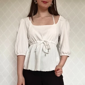 Vit blus med knyt och puffärm - Supersöt vit blus med fyrkantig ringning, trekvarts puffärmar och knyt i midjan. Från Lager 157🥰