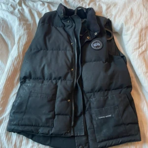  Canada Goose vest black label  - Canada Goose väst black label, sällsynt modell. Cond:6/10, sparsamt använd.  Size är M, sitter dock som en L.                                                          En kemtvätt och den är skicket som en helt ny!                                  Lite små flaws, sista knappen är bortplockad. Dragkedjan är lite körig går dock att fixa hos en bra skrädderi för en rimlig peng.                            Priset är justerbart.