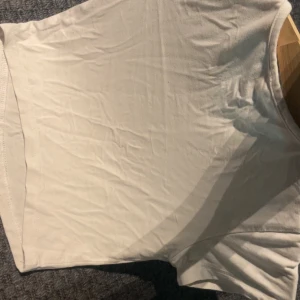 Vit kortärmad topp från Hot Hot - En basic vit topp från Hot Hot med rund halsringning och korta ärmar. Modellen är enkel och rak, perfekt att matcha med jeans eller kjol. Tillverkad i mjuk bomull som känns skön mot huden.