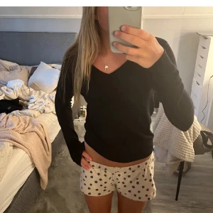 Svart v-ringad stickad tröja - Säljer en svart stickad tröja med v-ringning och långa ärmar. Tröjan har en enkel och stilren desig. Mjuk och skön att bära, perfekt för kyligare dagar. !! Den har tyvärr et håll i armen vid handen men de är nå ett lätt problem att fixa!! 