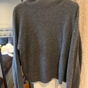 Grå stickad polotröja - Mysig grå stickad polotröja med ribbade muddar och hög krage. Perfekt för kyliga dagar och enkel att matcha med jeans eller kjol. Långärmad och i en klassisk, avslappnad passform. Skriv för fler bilder💕