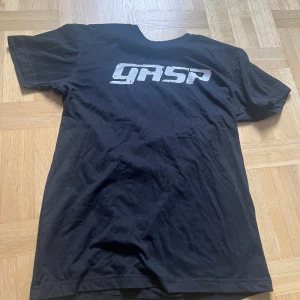 Svart GASP t-shirt med tryck - Svart t-shirt från GASP med stort vitt logotryck på bröstet. Klassisk passform med korta ärmar och rund halsringning. Perfekt för dig som gillar sportiga och stilrena plagg.