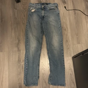 Replay ljusblå jeans straight fit - 160 storlek Säljer ett par klassiska ljusblå jeans från Replay med snyggt slitna detaljer och raka ben. Jeansen har fem fickor, normal midja och en ikonisk Replay-lapp bak i midjan. Perfekta till sneakers och hoodie för en chill look. HÅL I FICKOR FRAM