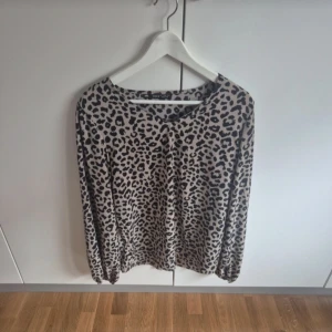 Leopardmönstrad långärmad tröja - Säljer en beige långärmad tröja med svart leopardmönster. Tröjan har rund halsringning och är i ett mjukt, material som känns skönt mot huden. 
