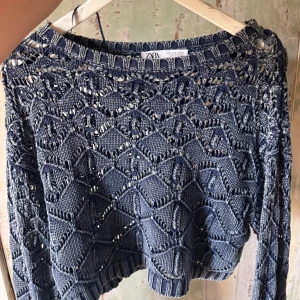 Blå virkad tröja från Zara - Säljer en blå stickad tröja från Zara med snyggt hålmönster och ribbade kanter. Perfekt att styla med jeans eller kjol. Superfin till både vår och höst!