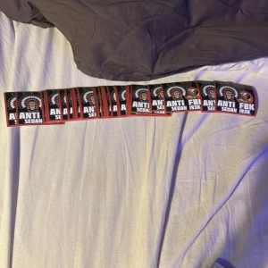 ANTI FBK SEDAN 1938 - Detta är ingen bok, utan en klistermärke med texten 'ANTI FBK SEDAN 1938' och en illustration av en indianhövding samt ett överstruket FBK-emblem. Perfekt för dig som vill visa ditt motstånd mot FBK på ett tydligt sätt.