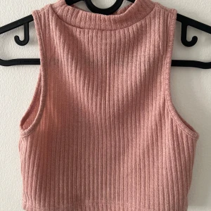 Rosa linne  - Säljer en ljusrosa ribbad croppad linnetopp från SHEIN. Toppen är ärmlös med hög hals. Jättefint skick, aldrig använd. 